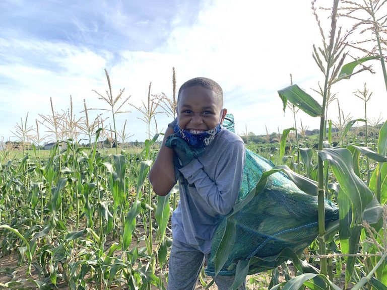 Smiling boy with corn